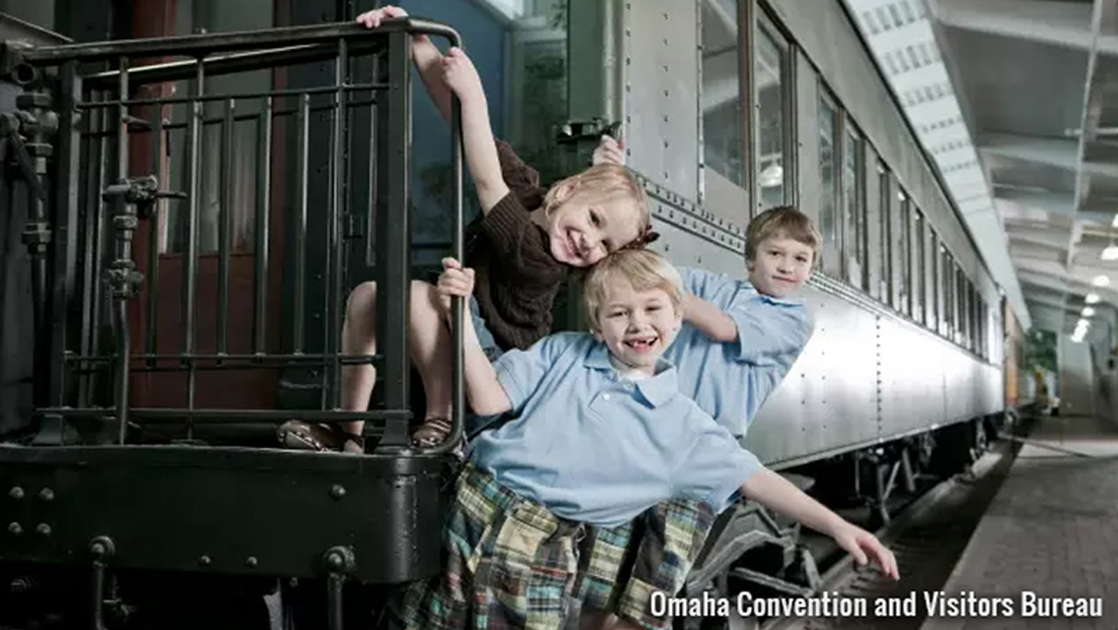 Children smiling on a train railing